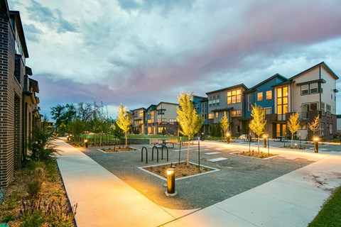 an empty parking lot in front of an apartment complex at dusk